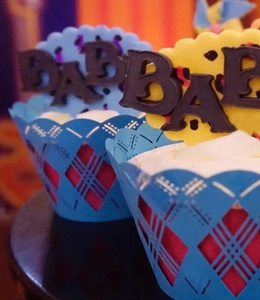 Detailed blue laser-cut cupcake lace wrapper with red liner and chocolate BABY topper