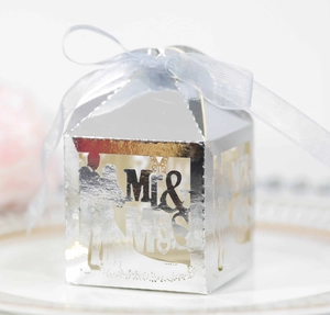 Macro detail of silver laser-cut Mr & Mrs wedding favor box with a blue ribbon