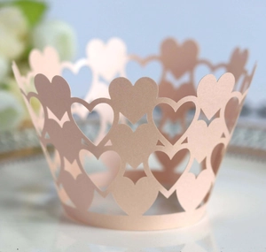Detail of laser-cut heart cupcake wrappers in pink on a porcelain plate