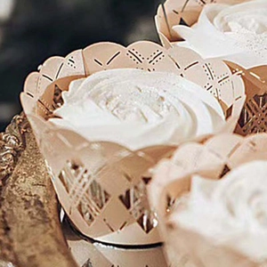Macro shot of laser-cut geometric champagne gold cupcake wrappers for party decoration