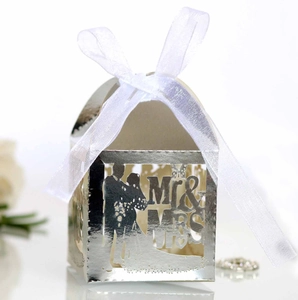 Macro shot of silver laser-cut wedding favor box with Mr & Mrs design and ribbon