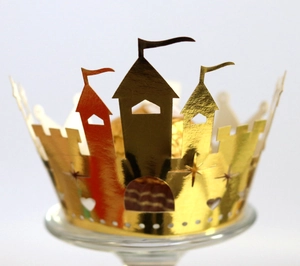 Close-up of golden castle party crown with hollow stars and hearts on a glass stand