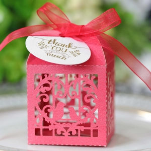 Détail d'une boîte de mariage rose découpée au laser avec motifs floraux et étiquette
