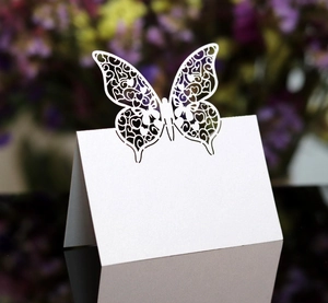 Macro detail of laser-cut butterfly place card made of white pearlescent paper