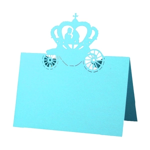 Detailed laser-cut blue wedding place card featuring a romantic carriage and crown silhouette