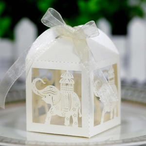Detailed close-up of laser-cut white elephant wedding favor box with organza ribbon bow
