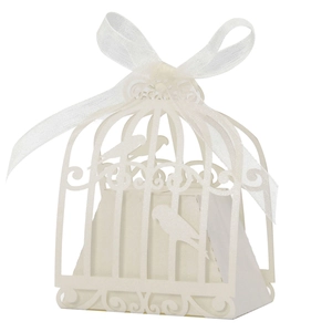 Detail of white laser-cut birdcage candy box featuring pearlescent paper and white ribbon