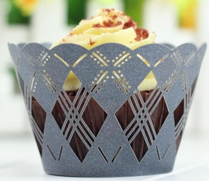 Close-up of grey laser-cut cupcake wrappers with geometric lace pattern for parties