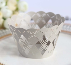 Intricate laser-cut pearl paper cupcake wrapper with geometric hollow patterns on silver