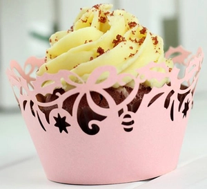 Detailed laser-cut pink cupcake wrapper with elegant floral patterns for wedding decor