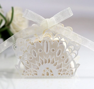 Detail of laser-cut peacock pattern on white pearlescent paper wedding candy box