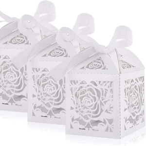 Detail of laser-cut white rose gift box featuring intricate hollow patterns and silk ribbon