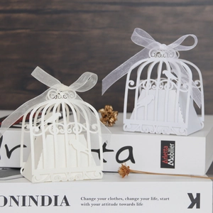 Macro shot of laser-cut wedding favor box with bird patterns and ribbon detail