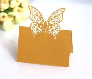 Detailed laser cut gold butterfly place card with heart patterns on pearl paper