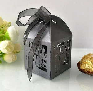 Detail of laser-cut Mr & Mrs wedding favor box in pearl silver with ribbon