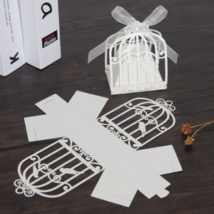 Laser-cut white birdcage candy box with intricate floral patterns and elegant ribbon bow