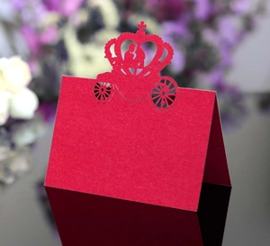 Detailed laser-cut red paper place card featuring crown and wedding carriage design