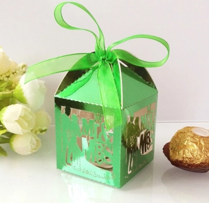 Detail of laser-cut green Mr & Mrs wedding favor box with ribbon and metallic finish