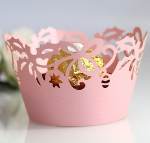 Close-up of pink laser-cut hollow cupcake wrappers with floral and star patterns