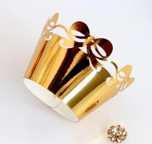 Detailed laser-cut gold cupcake wrapper with bow patterns and mirror foil finish