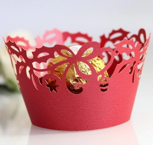 Macro detail of red laser-cut cupcake wrapper with elegant leaf patterns and chocolate