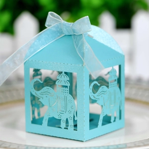 Detail of light blue laser-cut elephant favor box with elegant silk ribbon bow