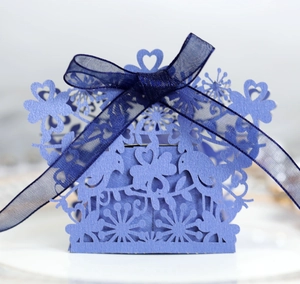 Elegant lavender laser-cut favor box with floral bird patterns and blue ribbon bow