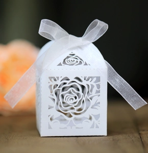 Macro shot of white laser-cut rose candy box with an elegant white organza ribbon bow