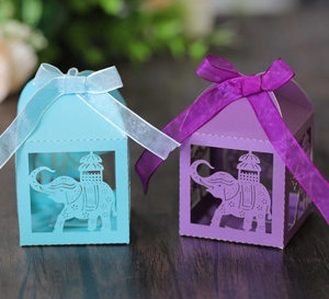 Detail showing laser-cut elephant pattern on paper candy gift boxes with ribbon bows
