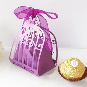 Detail of purple laser-cut birdcage candy box with delicate organza ribbon and bow