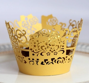 Golden laser-cut hollow cupcake wrappers with floral patterns for party dessert table