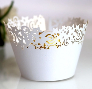 Macro detail of laser-cut white cupcake wrapper with star and spiral lace patterns