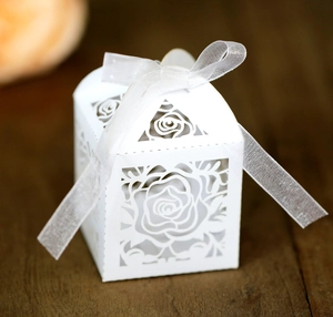 Elegant white laser-cut rose hollow wedding favor box with a white ribbon tie