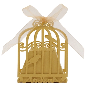 Detail of golden laser-cut birdcage candy box with intricate floral patterns and organza bow