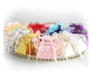 Laser cut hollow bird and heart candy boxes with silk bows in assorted colors for weddings