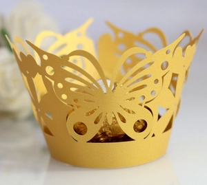 Laser-cut butterfly hollow cupcake wrappers in gold pearlescent paper for wedding decor