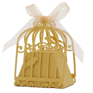 Close-up of golden hollow birdcage wedding candy box with elegant ribbon bow