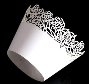 Detailed laser-cut white paper cupcake wrapper with intricate rose floral patterns