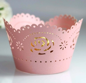 Macro shot of pink laser-cut rose cupcake wrappers with pearlescent gold lining detail