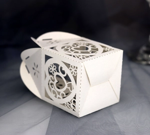 Detailed laser-cut heart pattern on white cardstock wedding favor gift box