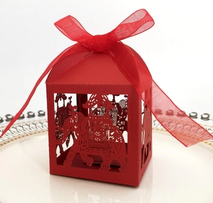 Detail of red laser-cut elephant candy box featuring a sheer organza ribbon bow