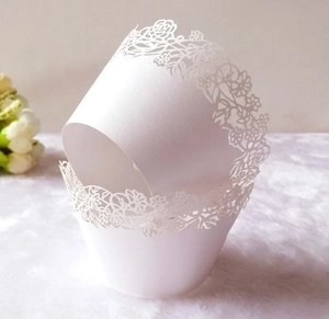 Macro shot of white laser-cut lace floral cake wrappers for wedding party decorations