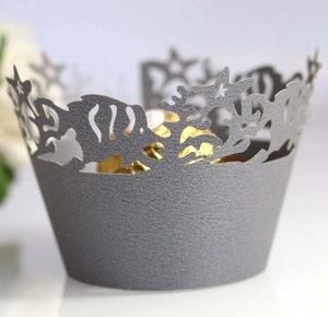 Macro detail of laser-cut fish and starfish patterns on ocean-themed cupcake wrappers