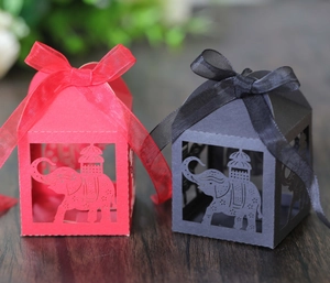 Detail of laser-cut elephant gift boxes with silk ribbons for wedding and party favors