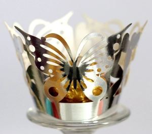 Macro shot of laser-cut gold butterfly cupcake wrappers with metallic mirror finish