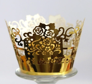 Detailed laser-cut golden cupcake wrapper featuring intricate floral and rose patterns