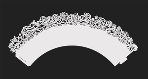 Detail of laser-cut white cupcake wrapper with intricate rose pattern and tab closure