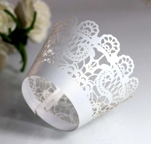 Macro shot of white pearlescent laser-cut lace cupcake wrapper with floral pattern