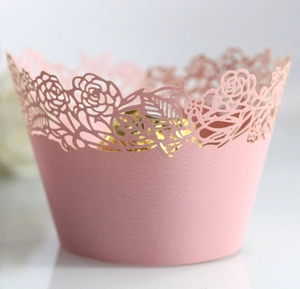 Detail of pink pearl paper cupcake wrapper featuring intricate laser-cut rose patterns