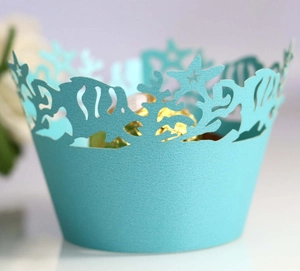Macro shot of laser-cut ocean theme cupcake wrappers with fish and coral in cyan blue